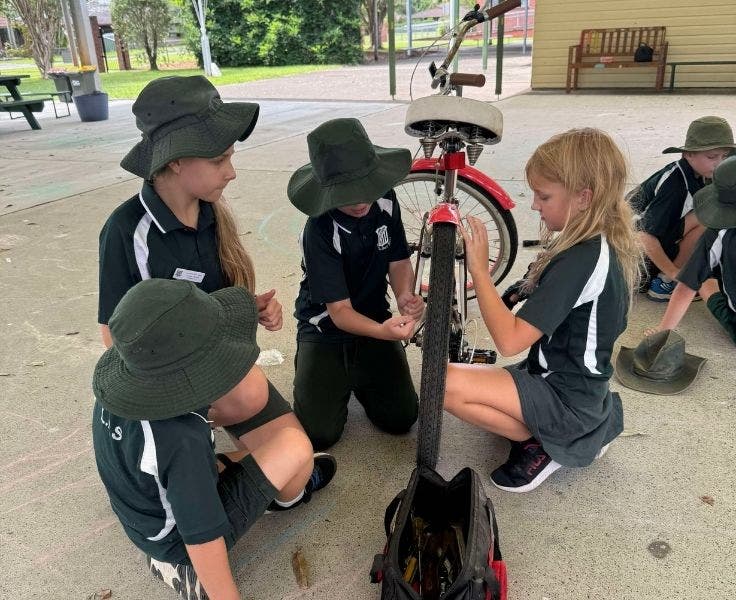 four student fixing a pushbike