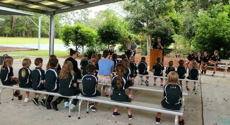 School assembly. Staff and students sitting and watching.