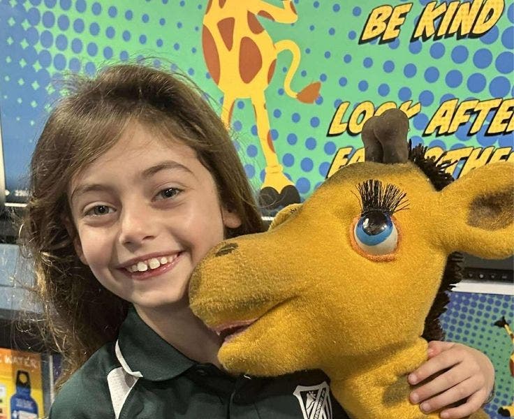 a student cuddling Health Harold the Giraffe