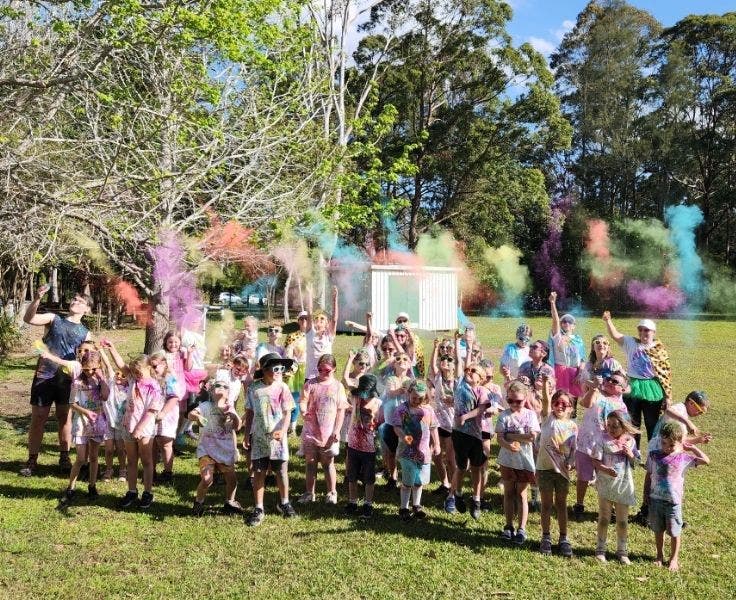 School students at the end of the colour run throwing colour up in the air